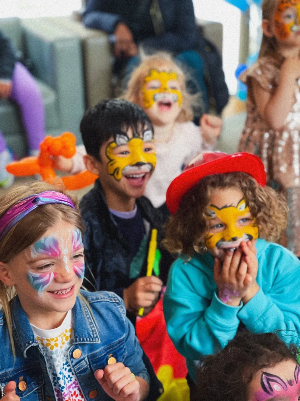 Group of children laughing together with colorful face paint at a real NYC Birthday Clowns party