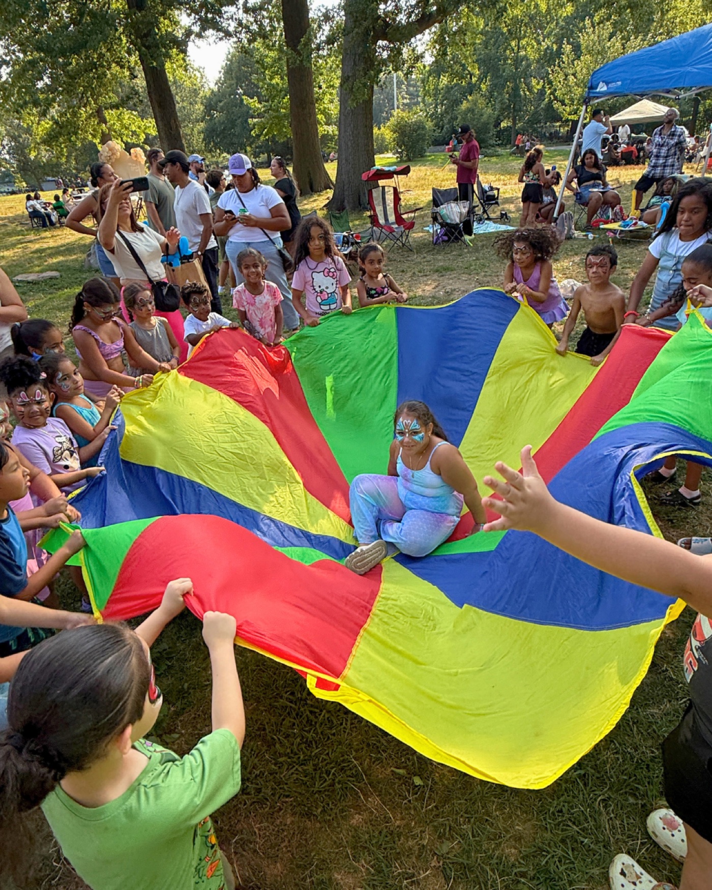 Children playing a colorful parachute game at an outdoor party