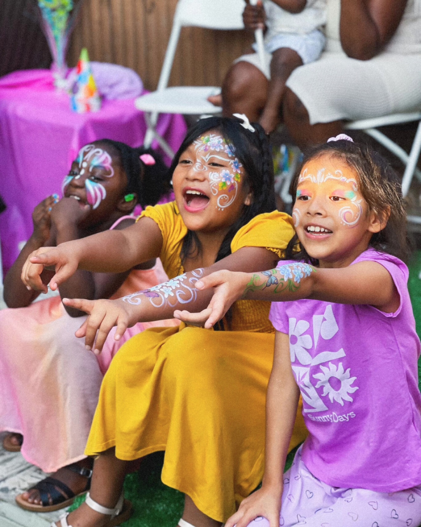 Three children laughing and reaching toward the entertainment at a real party
